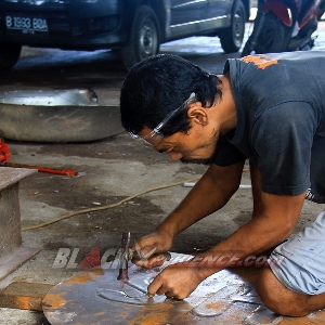 Mengemal plat untuk menutup bagasi yang sudah dipotong