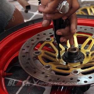 Salah seorang crew Obelix Xtreme Motorcyle memasang disc brake